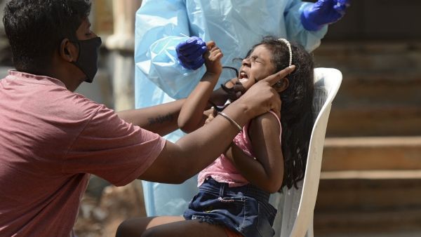 A girl reacts as a health worker wearing protective gear prepares to collect her swab sample to test for the Covid-19 coronavirus at sample collection centre in Hyderabad on October 29, 2020. India on October 29 passed eight million coronavirus cases, with the world's second-worst-hit country bracing for a possible second wave ahead of winter and a series of religious festivals. NOAH SEELAM / AFP