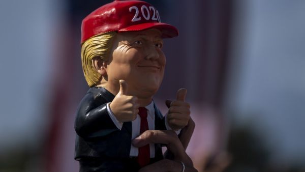 A supporter waves a Donald Trump figurine during a Make America Great Again campaign rally in Tampa, Florida on October 29, 2020. Ricardo ARDUENGO / AFP
