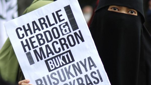 A Muslim demonstrator holds a placard during a protest against French President Emmanuel Macron for his comments over the Prophet Mohammed caricatures, in Bandung on October 30, 2020. Timur Matahari / AFP
