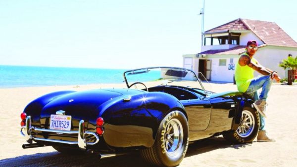 هاميلتون يجلس على مقدمة سيارته شيلبي كوبرا موديل 1966 البالغ ثمنها 4 ملايين جنيه استرليني