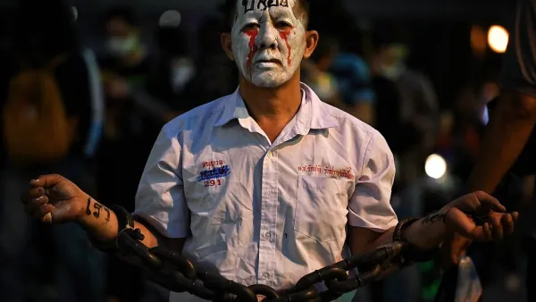 A pro-democracy protester wears chains and make-up during a demonstration at a road intersection in Bangkok today, after Thailand issued an emergency decree following an anti-government rally the previous day. (AFP/File)