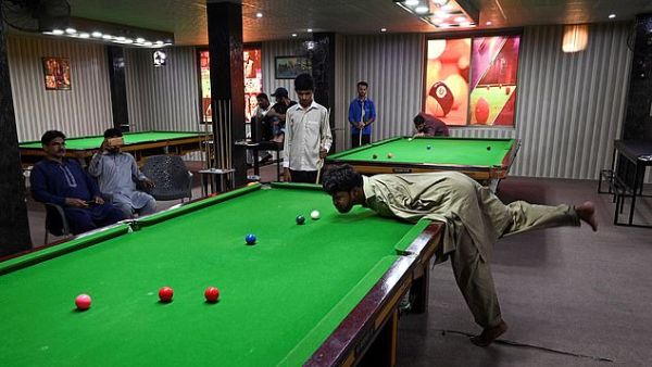 Mr Ikram crooks his neck to take aim and bends over to sink a rebound shot. (AFP)