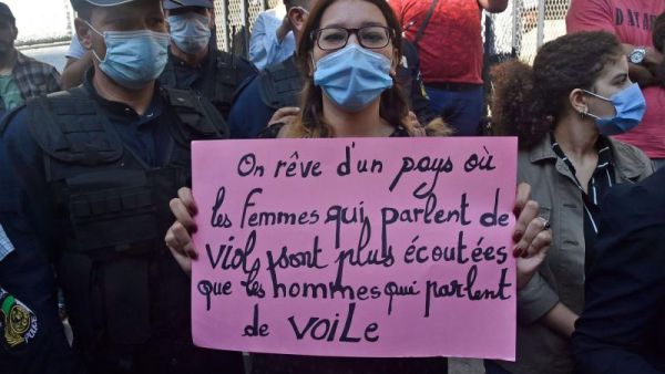 An Algerian activist holds a placard reading in French, “We dream of a country where women who talk about rape are listened to more than men who talk about the veil” during a rally in the capital Algiers, this month. (AFP)