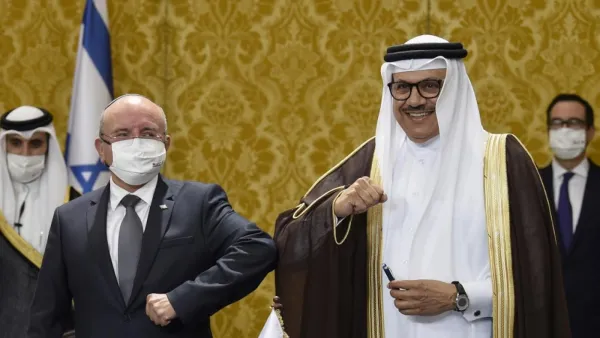Bahraini Foreign Minister Abdullatif bin Rashid al-Zayani, right, and Israeli National Security Adviser Meir Ben Shabbat bump elbows after signing ceremony in Manama on 18 October (AFP/File photo)