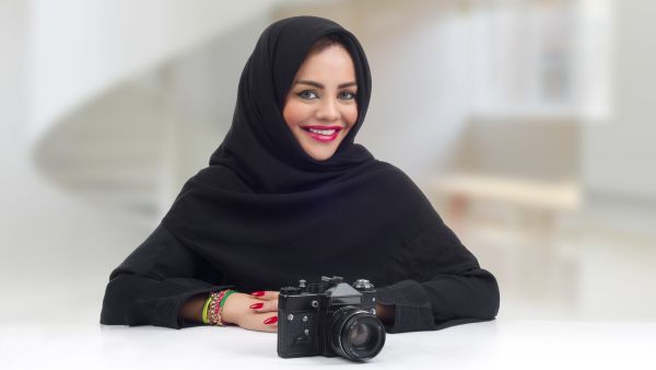 Ambitious Arabian photographer posing with her professional camera (Shutterstock) Ambitious Arabian photographer posing with her professional camera (Shutterstock)