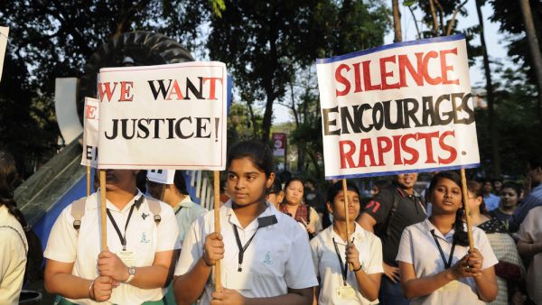 School girls in uniform holding signs asking for justice during a candle light vigil to protest gang rape of an elderly nun on March 16, 2015 at Allen Park in Kolkata, India. (Shutterstock/ File Photo)