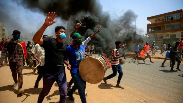 Sudanese demonstrators carrying a drum gesture as smoke billows from burning tires during a protest east of the capital Khartoum, Sudan, June 30, 2020. Ashraf Shazly/AFP via Getty Images, FILE