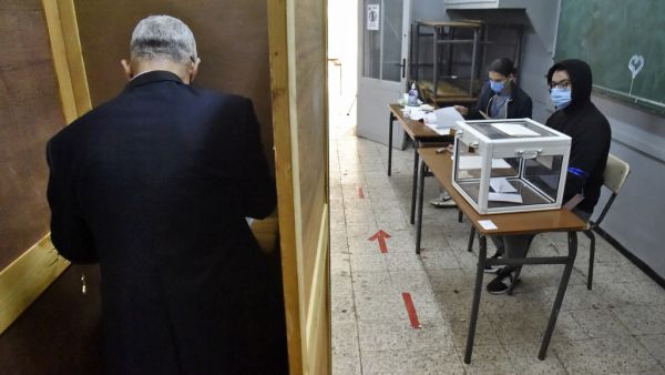 An Algerian man prepares to vote at a polling station in the capital Algiers during a vote for a revised constitution, on November 1, 2020. Polls opened in Algeria today for a vote on a revised constitution the regime hopes will neutralise a protest movement which at its peak last year swept long-time president Abdelaziz Bouteflika from power. RYAD KRAMDI / AFP