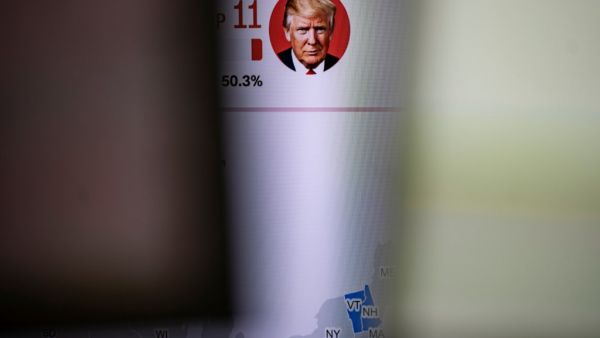 A news channel features portrait of US presidential candidates Donald Trump is pictured at a foreign exchange trading company in Tokyo on November 4, 2020, as Asian markets react to early predictions following the US presidential election. Philip FONG / AFP
