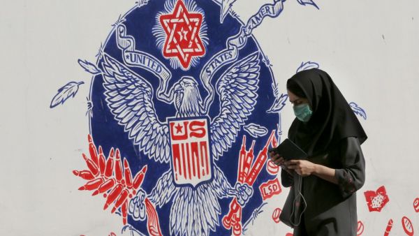An Iranian woman walks past a mural painted on the outer walls of the former US embassy in the Iranian capital Tehran, on November 4, 2020 as the US waits for the results of the presidential election. ATTA KENARE / AFP