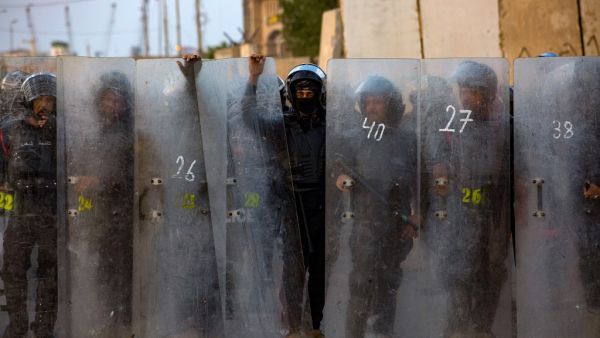Iraqi riot police form a barier as demonstrators gather near the local administration building in the southern city of Basra on November 6, 2020, during an anti-government protest. Hussein FALEH / AFP
