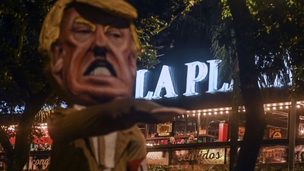 People look at a dummy depicting United States President Donald Trump making a Nazi salute from a restaurant during a protest against him in Medellin, Colombia, on November 6, 2020, in the framework of the US election. A US Supreme Court justice on Friday denied a request by Pennsylvania's Republicans to immediately halt the counting of ballots arriving after Election Day -- referring the challenge to the full court for a ruling on Saturday. JOAQUIN SARMIENTO / AFP