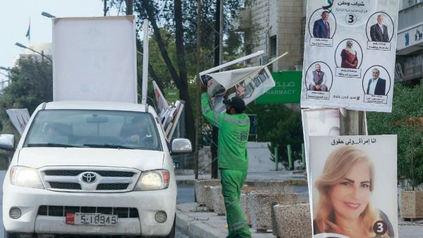 Jordanian minicipal workers remove campaign posters a day after parliamentary elections in the capital Amman, on November 11, 2020. Jordanians voted on November 10 in a parliamentary election overshadowed by the coronavirus pandemic, which has dealt a heavy blow to the Arab country's already debt-ridden economy. Khalil MAZRAAWI / AFP