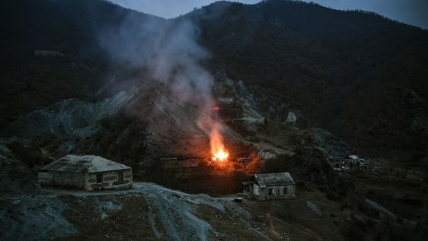 A house burns in a village outside the town of Kalbajar, on November 14, 2020, after a peace agreement was signed to end the military conflict between Armenia and Azerbaijan over the disputed Nagorno-Karabakh region. Villagers outside of Nagorno-Karabakh set their homes on fire on November 11 before fleeing to Armenia ahead of a weekend deadline that will see some disputed territory handed over to Azerbaijan as part of a peace agreement. Residents of the Kalbajar district in Azerbaijan, which has been contr