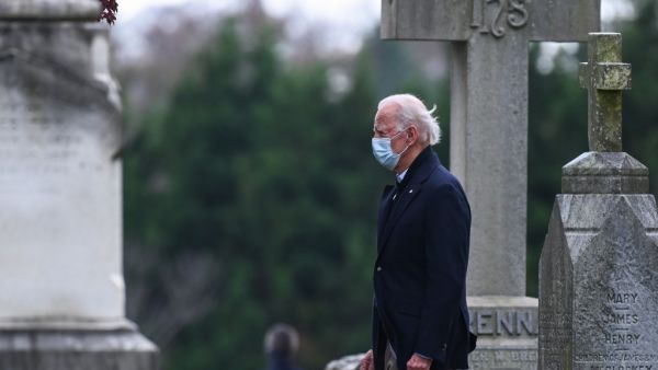 US President-elect Joe Biden walks past tombstones after leaving the St. Joseph on the Brandywine Catholic Church after attending Mass in Wilmington, Delaware on November 15, 2020. AFP