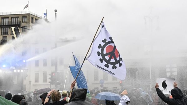 Police use a water cannon to disperse protesters demonstrating against measures imposed by the German government to limit the spread of the novel coronavirus, on November 18, 2020 at the Brandenburg Gate in Berlin. After repeated warnings for the crowd to put on face coverings went unheeded, police said they would take action to clear the protest and "detain violators". Around 5,000 activists massed at the Brandenburg Gate, after the German government banned rallies outside parliament because of fears of vi