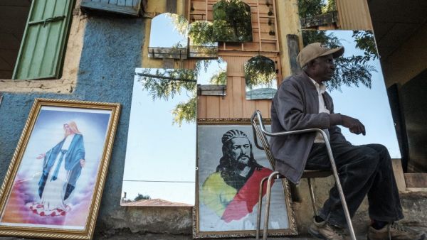 A man seats in front of a shop selling mirrors and paintings in Gondar, Ethiopia, on November 23, 2020. EDUARDO SOTERAS / AFP