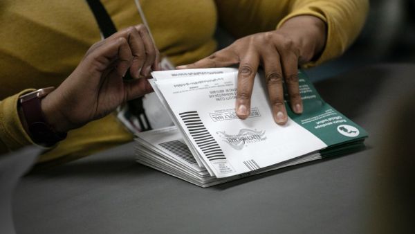 Election workers sort absentee ballots to count at the Lansing city clerk's office on election night on November 03, 2020 in Lansing, Michigan. President Trump narrowly won Michigan in 2016, and both he and Joe Biden campaigned heavily in the battleground state in 2020. John Moore/Getty Images/AFP JOHN MOORE / GETTY IMAGES NORTH AMERICA / Getty Images via AFP