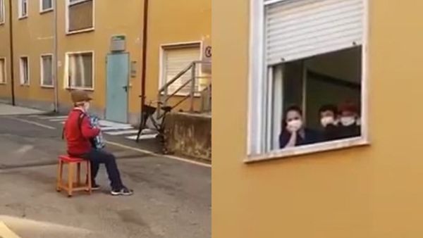 Stefano Bozzini (left) plays his accordion to his wife Carla Sacchi (right) from the street below. (Facebook)