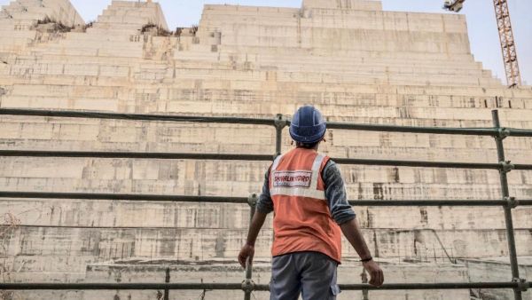 Construction worker eyes progress on the Grand Ethiopian Renaissance Dam in Ethiopia last December (AFP)
