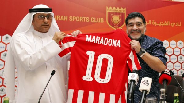 Photo taken on May 14, 2017  Diego Armando Maradona (R) holds a jersey of the football club Fujairah FC, bearing his name, during a press conference where he was announced as the upcoming manager for the team (Photo: AFP)