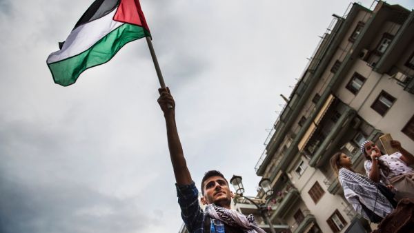 A Palestinian waves  flag (Shutterstock)