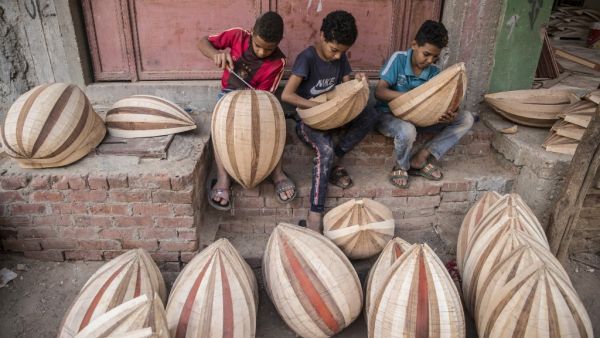 Children work on Arabian Ouds at a workshop belonging to Khaled Azzouz, a veteran oud-maker at the al-Marg district on the outskirts of the Egyptian capital Cairo on October 26, 2020. Azzouz said he had observed "unprecedented interest" in the out during the global health pandemic. Occasionally, children from the neighbourhood earn pocket money by doing odd jobs at the workshop, such as removing staples from the unfinished oud bodies, Azzouz said. Khaled DESOUKI / AFP