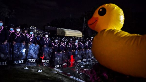 A large inflatable duck is displayed facing riot police as pro-democracy protesters take part in an anti-government rally outside the 11th Infantry Regiment in Bangkok on November 29, 2020. Lillian SUWANRUMPHA / AFP