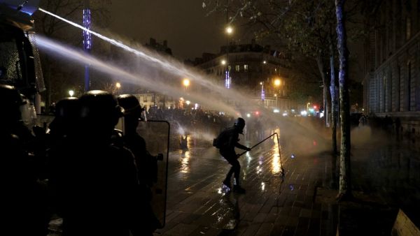 French anti-riot policemen use a watercannon against protesters during a demonstration for 'social rights' and against the 'global security' draft law, which Article 24 would criminalise the publication of images of on-duty police officers with the intent of harming their 'physical or psychological integrity', in Paris, on December 5, 2020. GEOFFROY VAN DER HASSELT / AFP