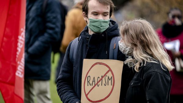 A couple holds a placard during a demonstration against racism at the Koekamp park in The Hague, The Netherlands on December 6 2020. Human rights and climate organisations staged the protest after a series of discriminatory actions, including the defacement of The Black Archives premises. Sander Koning / ANP / AFP