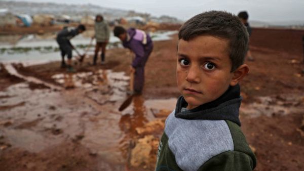 A Syrian child poses for a picture at a camp for displaced Syrians near the town of Kafr Lusin by the border with Turkey, in Syria's rebel-held northwestern province of Idlib on December 15, 2020. Aaref WATAD / AFP