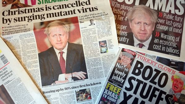 An arrangement of UK daily newspapers photographed as an illustration in Liverpool on December 20, 2020, shows front page headlines reporting on the story of Britain's Prime Minister Boris Johnson introducing new tougher coronavirus COVID-19 restrictions for London and the South East of England, cancelling Christmas gatherings for those in the new 'tier 4' category. British Prime Minister Boris Johnson on Saturday announced a "stay at home" order for London and southeast England to slow a new coronavirus st