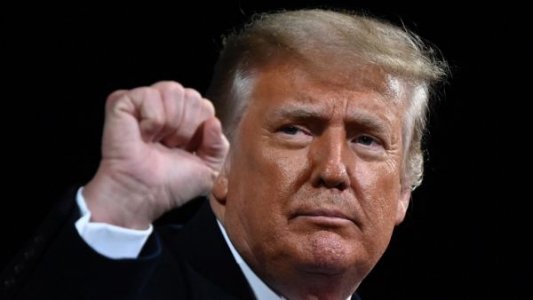 In this file photo US President Donald Trump raises his fist at the end of a rally to support Republican Senate candidates at Valdosta Regional Airport in Valdosta, Georgia on December 5, 2020. With one month to go until Joe Biden takes office, Donald Trump remains fixated on his failed bid to overturn the 2020 election -- with his advisors reportedly floating the idea of invoking martial law, triggering outrage and disbelief in Washington. Trump has stayed largely out of sight as several hugely consequenti