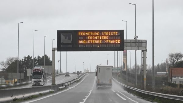 A truck drives by a sign indicating the border closure from England to France on a road in Calais on December 21, 2020 as countries worldwide banned arrivals from the UK on december 20 over a new highly infectious coronavirus strain Britain said was "out of control", as the WHO called for stronger containment measures.  DENIS CHARLET / AFP