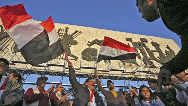 Iraqi protesters take part in a demonstration at Tahrir Square in Baghdad on December 21, 2020. Hundreds of angry Iraqis protested in several cities against a currency devaluation that has slashed their purchasing power amid a pandemic-fuelled economic crisis. The Central Bank of Iraq at the weekend devalued the dinar by nearly a quarter against the US dollar, officially re-pegging the dinar at 1,450 to the greenback.  Sabah ARAR / AFP