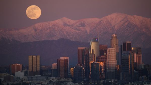 The last full moon of 2020, also known as the Cold Moon, rises behind the snow-topped San Gabriel Mountains and the Los Angeles downtown skyline at sunset as seen from the Kenneth Hahn State Recreation Area on December 29, 2020 in Los Angeles, California. Patrick T. Fallon / AFP
