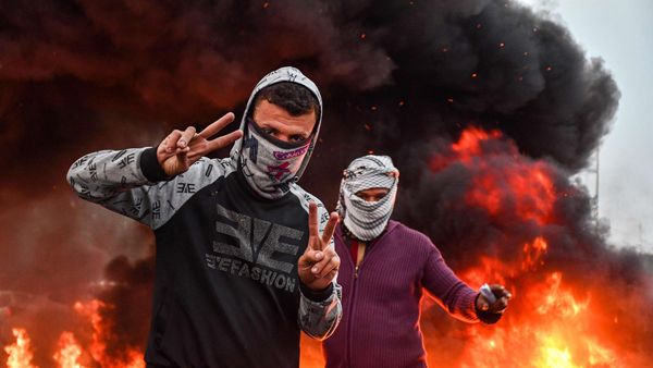 Masked protesters during an anti-government demonstration in Habboubi square in the centre of Iraq’s southern city of Nasiriyah in Dhi Qar province on November 29, 2020. (AFP),