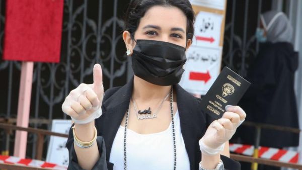 A Kuwaiti woman voter arrives to cast her ballot at a polling station in Kuwait City during parliamentary elections on December 5, 2020. (AFP)