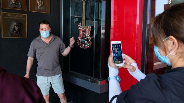 A man poses next to an Eddie Van Halen’s guitar displayed at the California Rockwalk of Fame in Los Angeles, Tuesday, Oct. 6, 2020. (shutterstock)