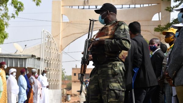 A Nigerien soldier stands guard as Niger's outgoing president Mahamadou Issoufou arrives at a polling station in Niamey on December 27, 2020 during Niger's presidential and legislative elections. Voters in the Sahel state of Niger go to the polls on December 27, 2020 for an election that could seal the country's first-ever peaceful handover between elected presidents, despite a bloody jihadist insurgency. Issouf SANOGO / AFP