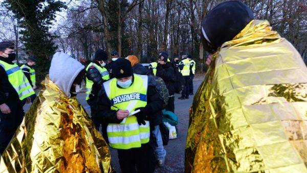 French Gendarmes writes down the details of youth following the break up of a party near a disused hangar in Lieuron about 40km (around 24 miles) south of Rennes, on January 2, 2021. Some 2,500 partygoers attended an illegal New Year rave in northwestern France, violently clashing with police who failed to stop it and sparking concern the underground event could spread the coronavirus, authorities said Friday. JEAN-FRANCOIS MONIER / AFP