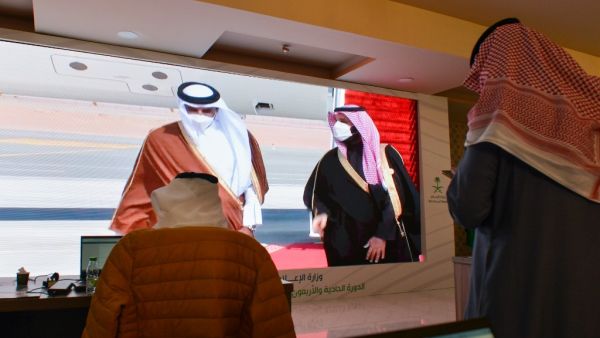 Journalists watch, Saudi Crown Prince Mohammed bin Salman (C-R) welcomes the Emir of Qatar Tamim bin Hamad Al-Thani (C-L), on a screen in the media centre ahead of the 41st Gulf Cooperation Council (GCC) summit in the city of al-Ula in northwestern Saudi Arabia on January 5, 2021. FAYEZ NURELDINE / AFP