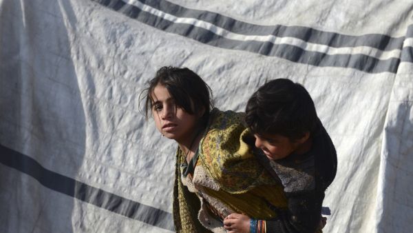 Children play next to a tent at a camp for internally displaced families in Dand district of Kandahar province on January 7, 2021. About 17,000 Afghan families from the Taliban bastion of Kandahar have fled their homes following months of heavy fighting between the insurgents and government forces despite peace talks, officials said  Javed TANVEER / AFP