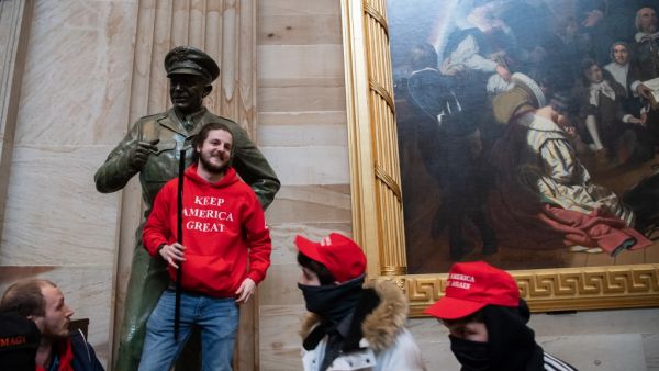 Supporters of US President Donald Trump pose with statues inside the Rotunda after breaching the US Capitol in Washington, DC, January 6, 2021. The demonstrators breeched security and entered the Capitol as Congress debated the 2020 presidential election Electoral Vote Certification. SAUL LOEB / AFP