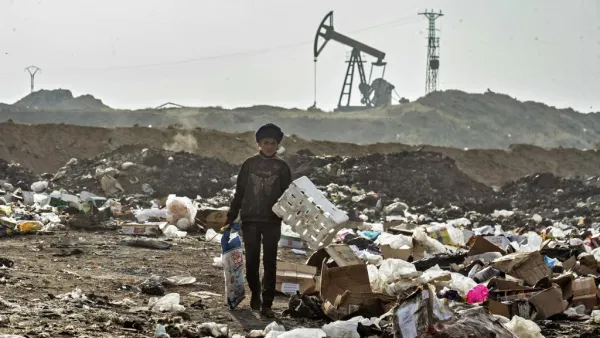 A Syrian child sifts through a garbage dump near an oil field in the countryside of Malikiya in northeast Syria, on January 12, 2021. On the dry plains outside the city of Al-Malikiyah, a dozen people wrapped up against the cold rip open the black plastic bags, in a desperate search for something to sell, repurpose or even eat. Across the road, an oil pump swings back and forth in this resource-rich region controlled by US-backed Kurdish forces.  Delil SOULEIMAN / AFP