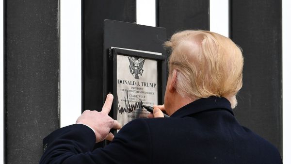 US President Donald Trump signs plaque on the border wall in Alamo, Texas on January 12, 2021. MANDEL NGAN / AFP