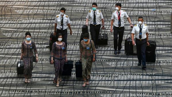 Singapore Airlines crew member walk along the transit hall of Changi International Airport terminal in Singapore on January 14, 2021. Roslan RAHMAN / AFP
