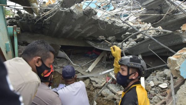 Rescuers search for survivors at the Mitra Manakarra hospital in Mamuju city on January 15, 2021, where as many as 20 patients and staff are trapped beneath the rubble after the hospital was flattened when a 6.2-magnitude earthquake rocked Indonesia's Sulawesi island. Firdaus / AFP