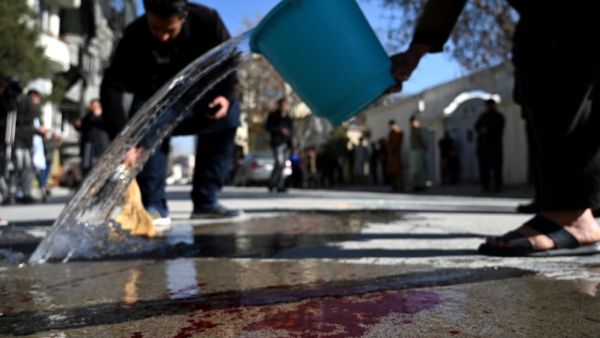 Residents wash a road following gunmen shot dead two Afghan women judges working for the Supreme Court, in Kabul on January 17, 2021. Gunmen shot dead two Afghan women judges working for the Supreme Court during an early morning ambush in the country's capital on January 17, officials said, as a wave of assassinations continues to rattle the nation. WAKIL KOHSAR / AFP
