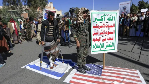 Supporters of Yemen's Huthi movement tread on US ans Israeli flags during a demonstration in front of the closed US embassy in the capital Sanaa on January 18, 2021, to reject the outgoing US administration's decision to designate the Huthis a "foreign terrorist organisation". Impoverished Yemen is mired in a devastating conflict between Iran-backed Huthi rebels and government forces backed by Saudi Arabia that has left tens of thousands dead and sparked a dire humanitarian crisis. Mohammed HUWAIS / AFP